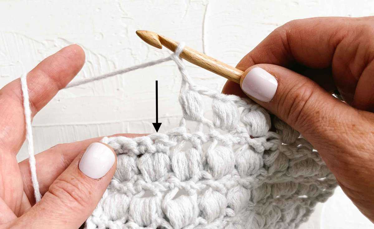 A row of crochet puff stitches in progress.