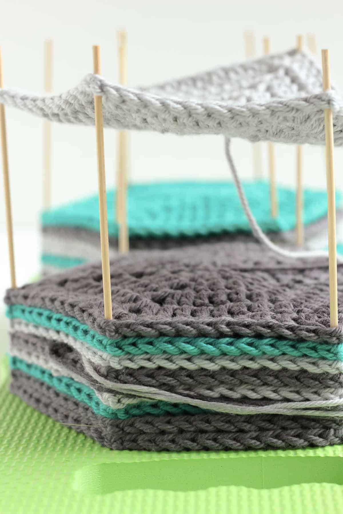 Blocking crochet hexagons using a DIY board and wooden skewers.