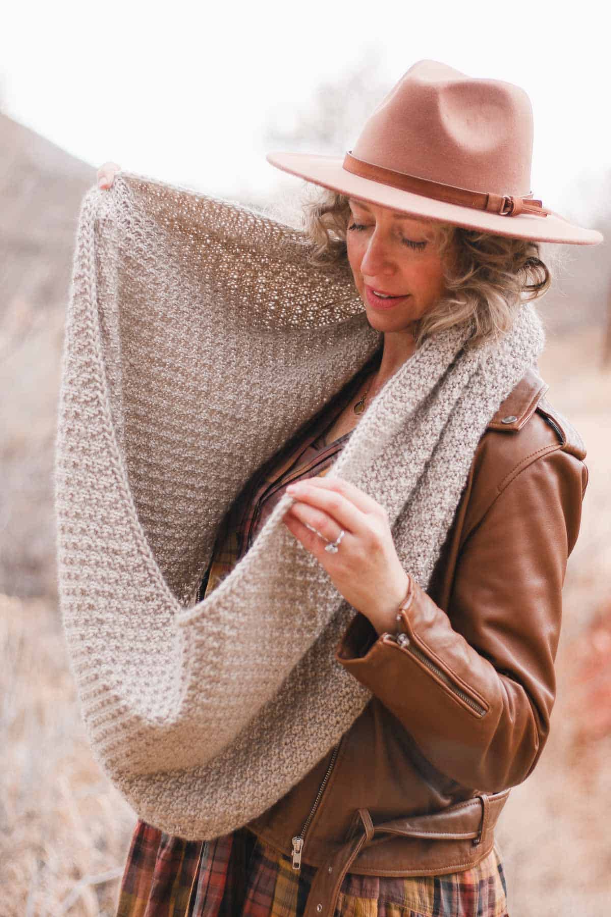 Drapey knit eternity scarf modeled by a woman outdoors. 