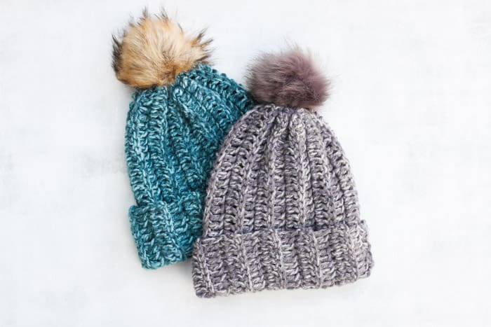 Two finished crochet hat patterns with pom poms.
